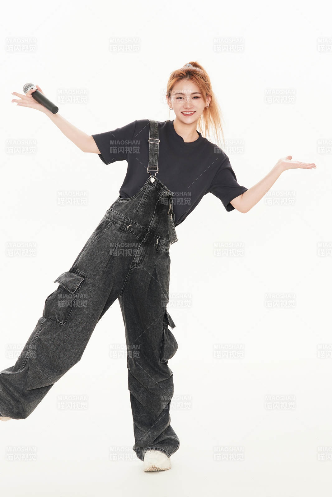 白色背景下手持麦克风的女性歌手图片