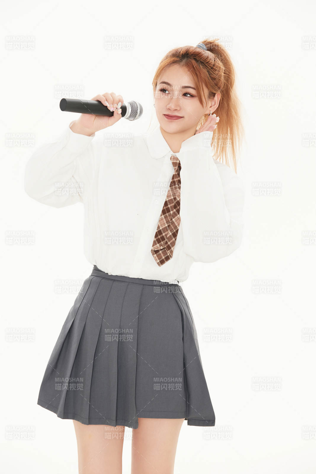 白色背景下站在麦克风前唱歌的亚洲女性图片