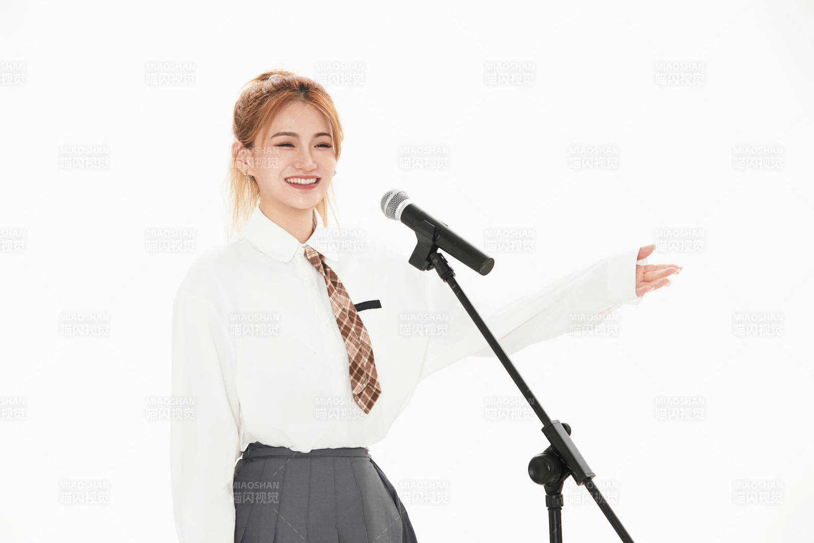 白色背景下站在麦克风前唱歌的亚洲女性图片