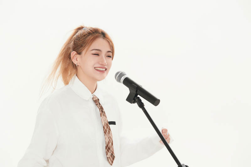 白色背景下站在麦克风前唱歌的亚洲女性图片