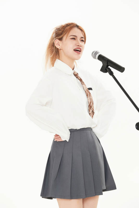 白色背景下站在麦克风前唱歌的亚洲女性图片