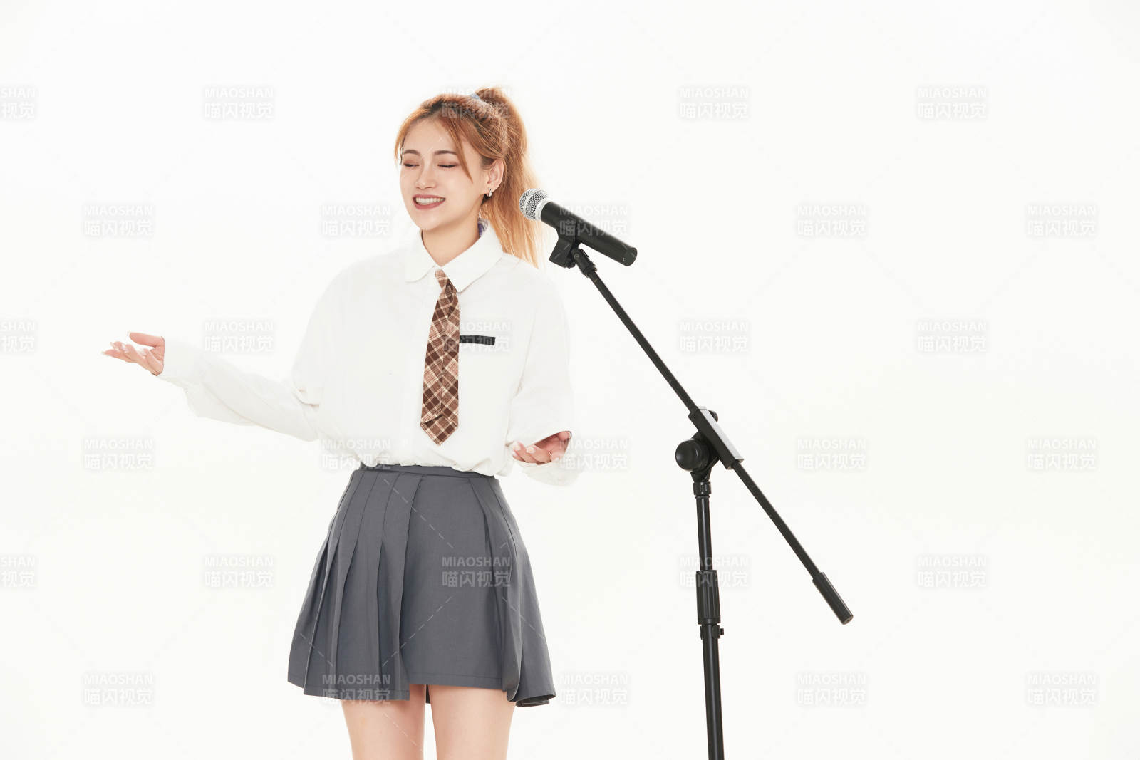 白色背景下站在麦克风前唱歌的亚洲女性图片