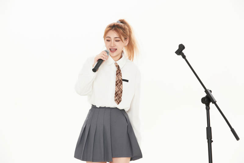 白色背景下站在麦克风前唱歌的亚洲女性图片