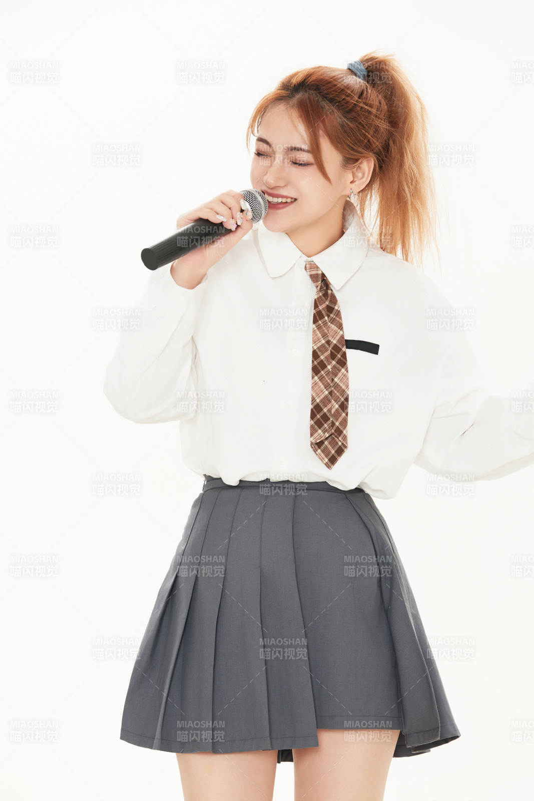 白色背景下站在麦克风前唱歌的亚洲女性图片
