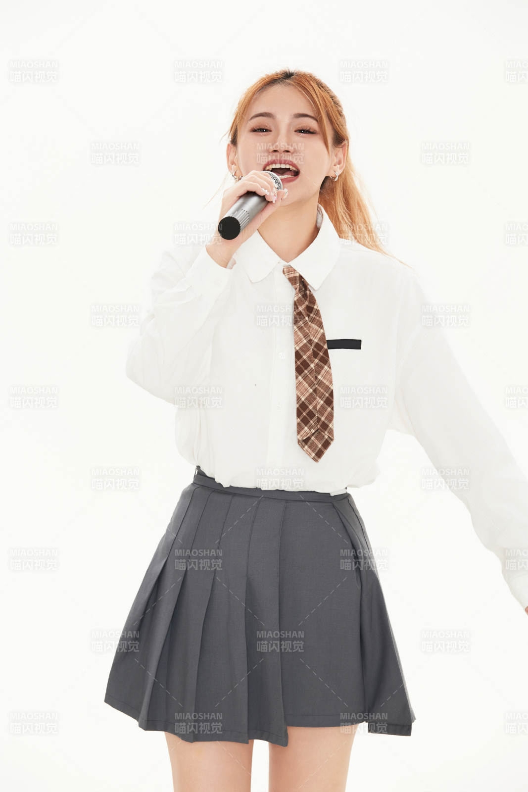 白色背景下站在麦克风前唱歌的亚洲女性图片