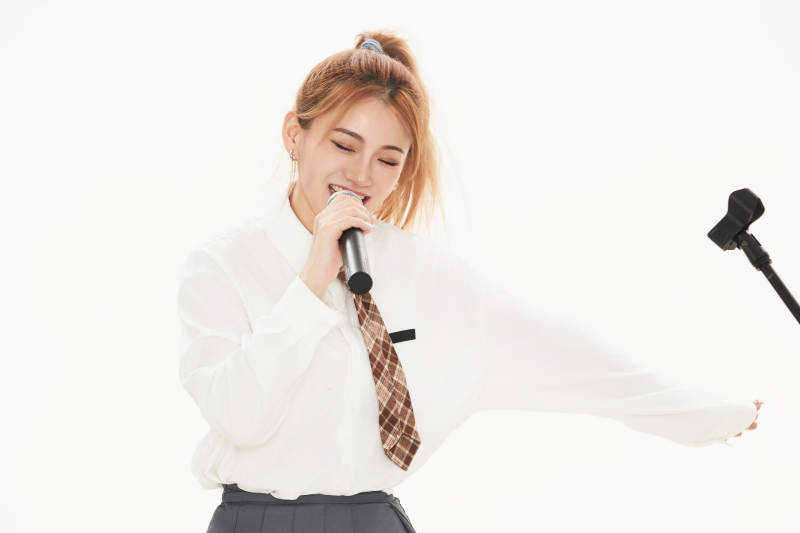 白色背景下站在麦克风前唱歌的亚洲女性图片
