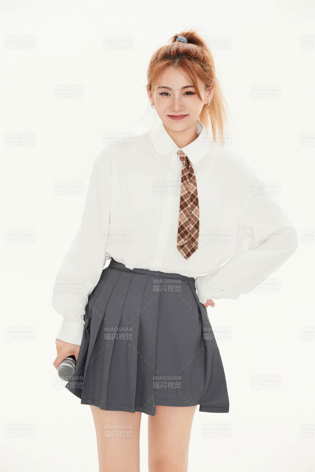 白色背景下站在麦克风前唱歌的亚洲女性图片