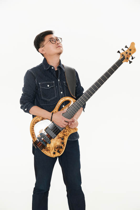 手持贝斯.低音吉他的亚洲男性乐手图片