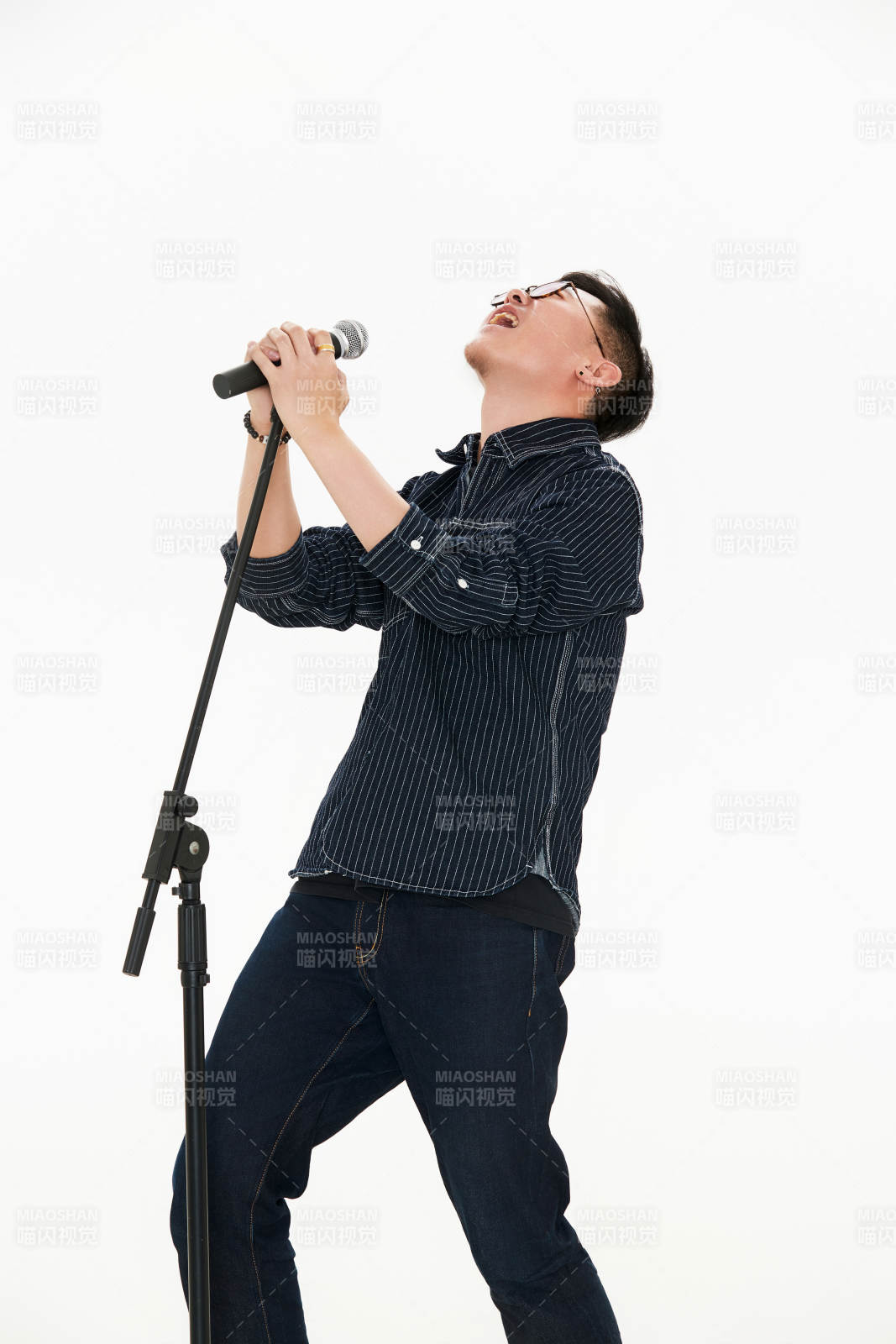 白色背景下站在麦克风前唱歌的亚洲男性图片