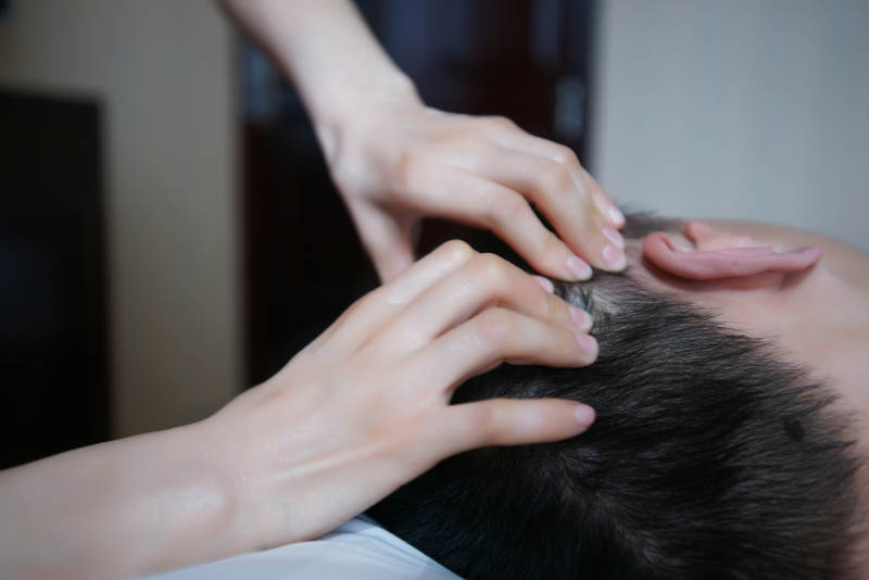 专业的按摩技师为顾客进行头部保健按摩图片