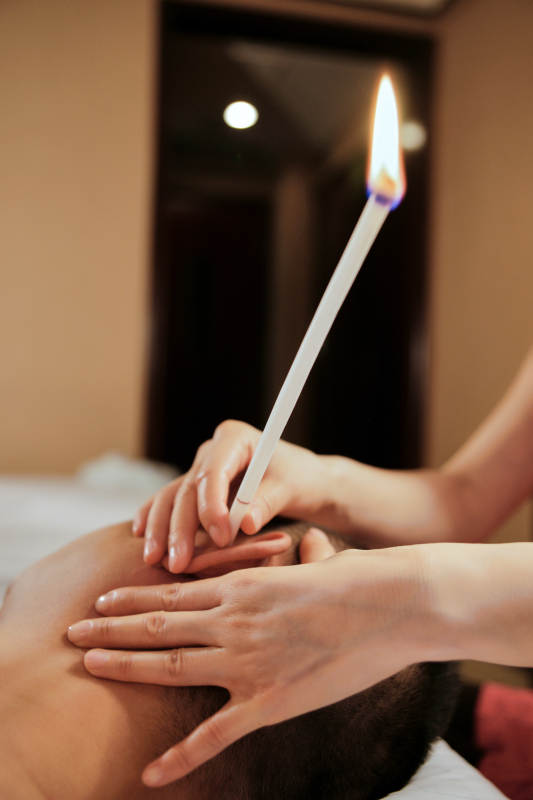 专业的按摩技师为顾客进行头部按摩及耳烛图片