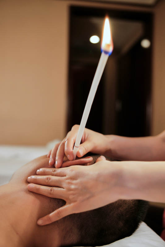 专业的按摩技师为顾客进行头部按摩及耳烛图片