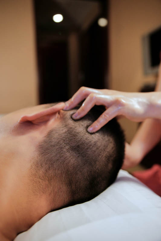 专业的按摩技师为顾客进行头部保健按摩图片