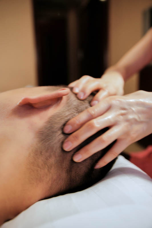 专业的按摩技师为顾客进行头部保健按摩图片