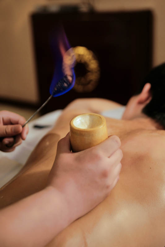 专业的保健技师为顾客进行吸筒疗法拔火罐图片