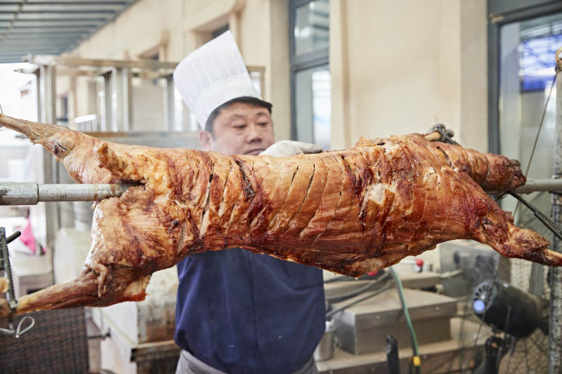 厨师在全神贯注的烤制全羊图片