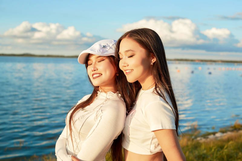 在旅游区湖边打卡点拍照的美女闺蜜图片