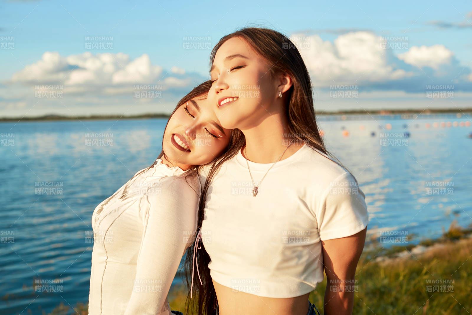 在旅游区湖边打卡点拍照的美女闺蜜图片