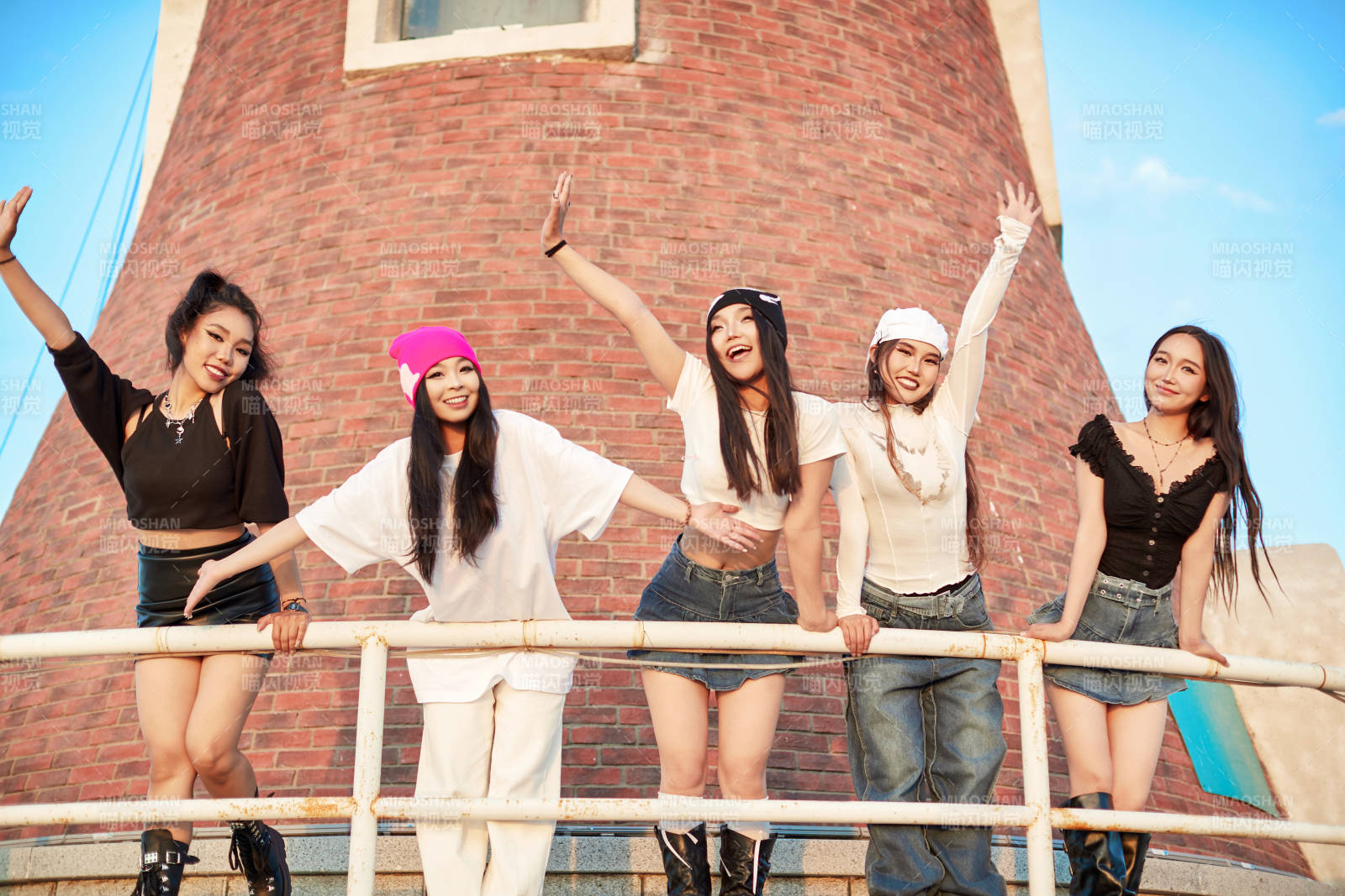 盛夏在草原湖边灯塔上拍照游玩的姑娘们图片