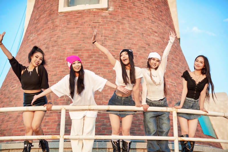 盛夏在草原湖边灯塔上拍照游玩的姑娘们图片