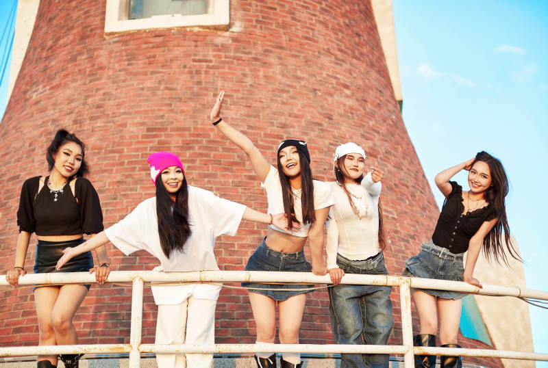 盛夏在草原湖边灯塔上拍照游玩的姑娘们图片