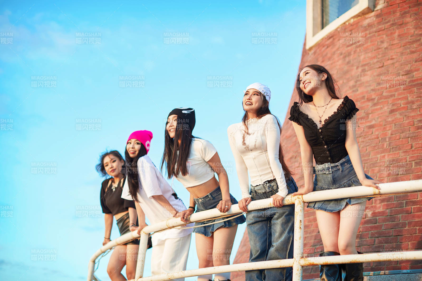 盛夏在草原湖边灯塔上拍照游玩的姑娘们图片