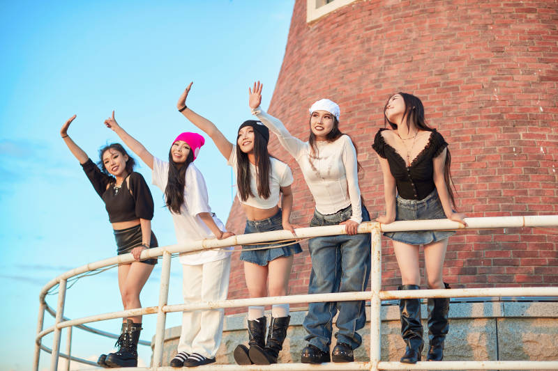 盛夏在草原湖边灯塔上拍照游玩的姑娘们图片