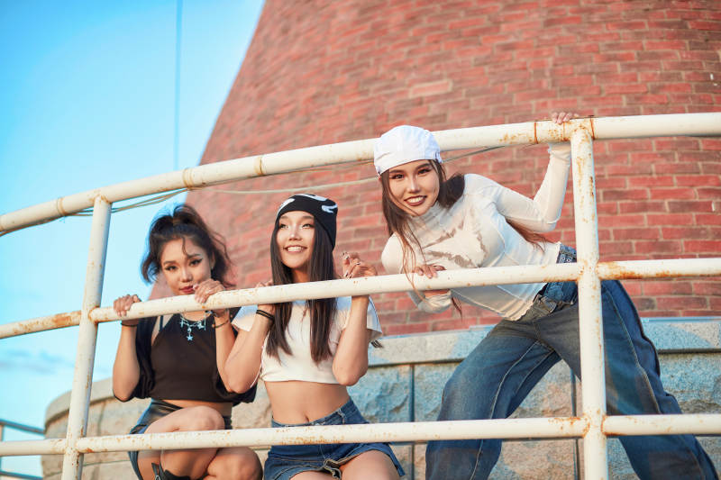 盛夏在草原湖边灯塔上拍照游玩的姑娘们图片