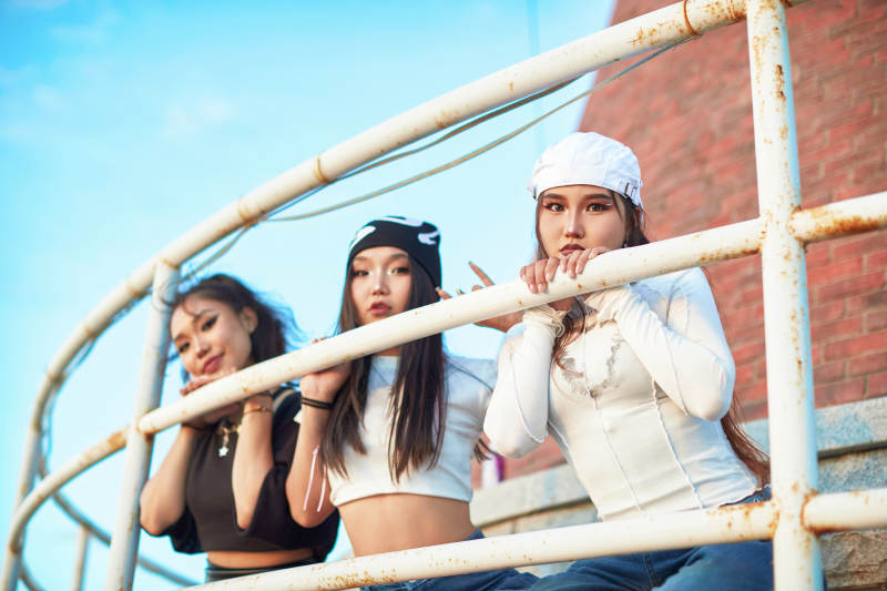 盛夏在草原湖边灯塔上拍照游玩的姑娘们图片