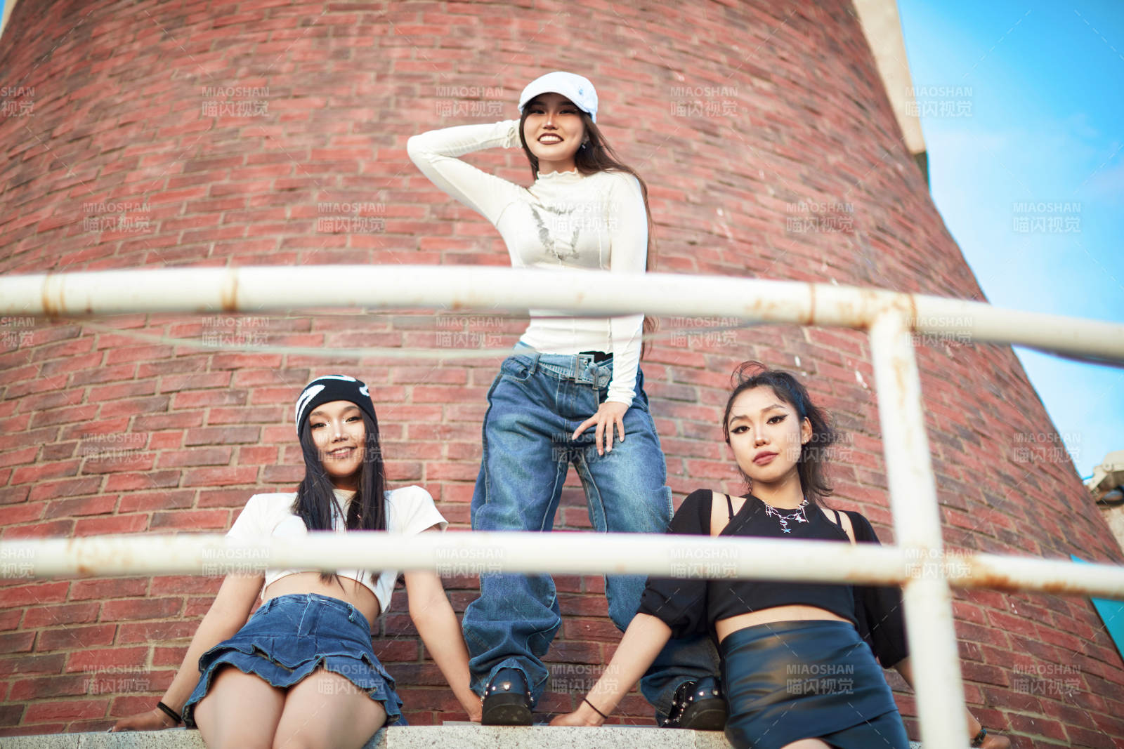 盛夏在草原湖边灯塔上拍照游玩的姑娘们图片