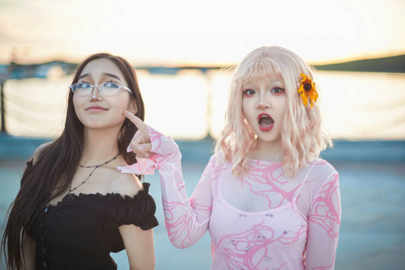 在旅游区湖边打卡点拍照的美女闺蜜图片