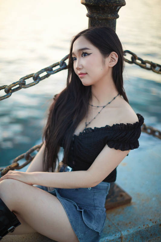 夕阳湖边打卡点拍照的美丽亚洲女性图片