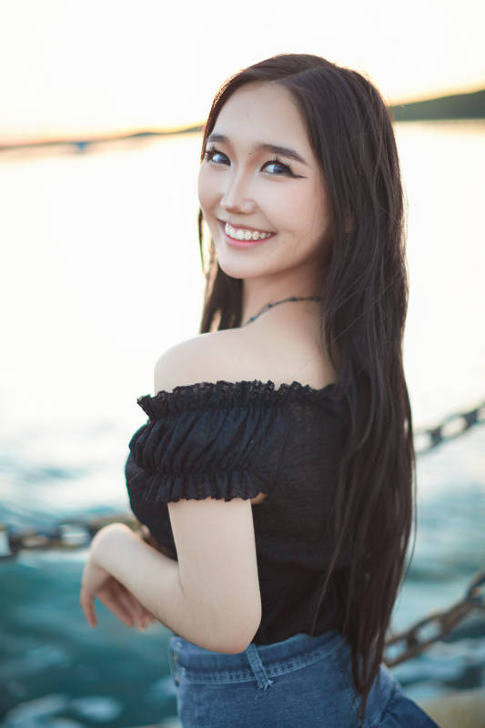 夕阳湖边打卡点拍照的美丽亚洲女性图片