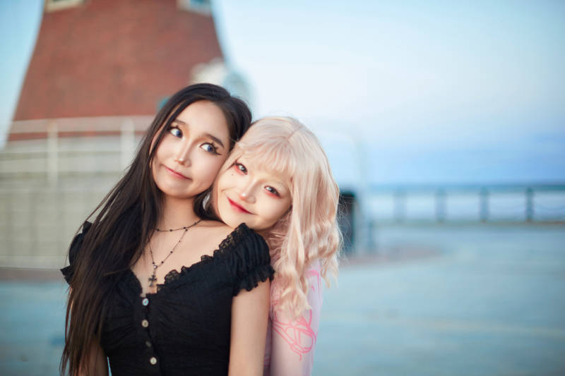 在旅游区湖边打卡点拍照的美女闺蜜图片