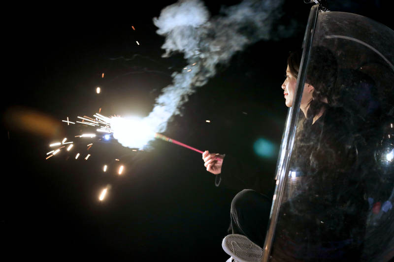 夜晚坐在透明秋千上燃放仙女棒的可爱少女图片