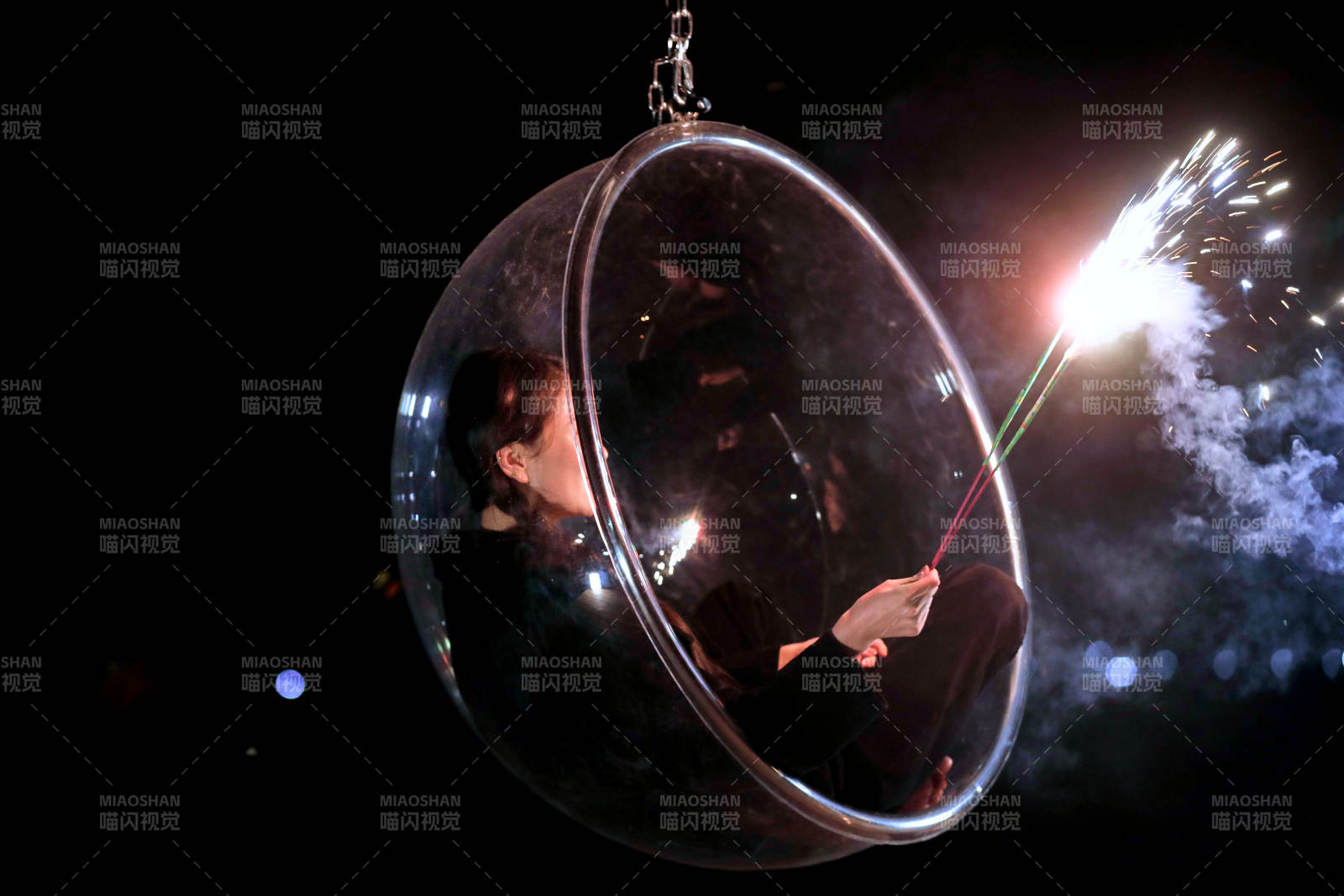 夜晚坐在透明秋千上燃放仙女棒的可爱少女图片