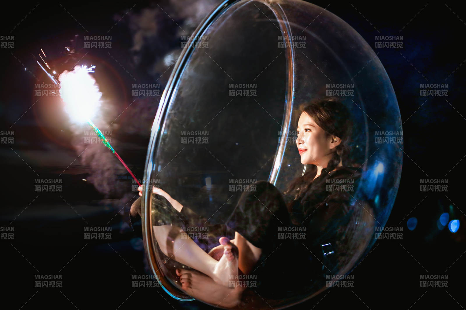 夜晚坐在透明秋千上燃放仙女棒的可爱少女图片