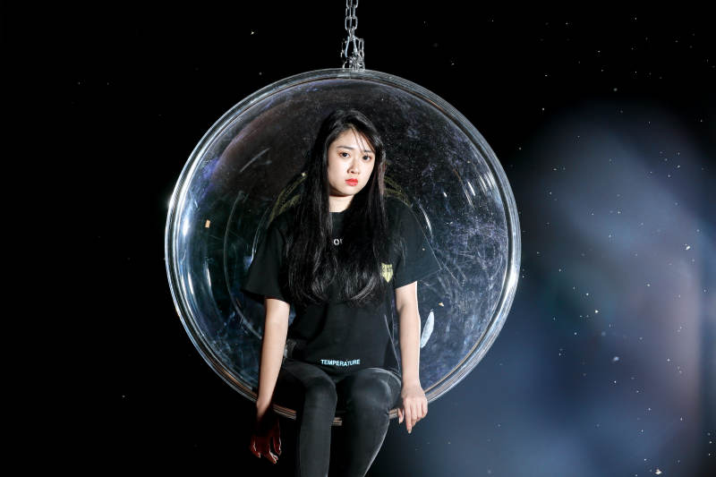 夜晚坐在透明秋千上燃放仙女棒的可爱少女图片