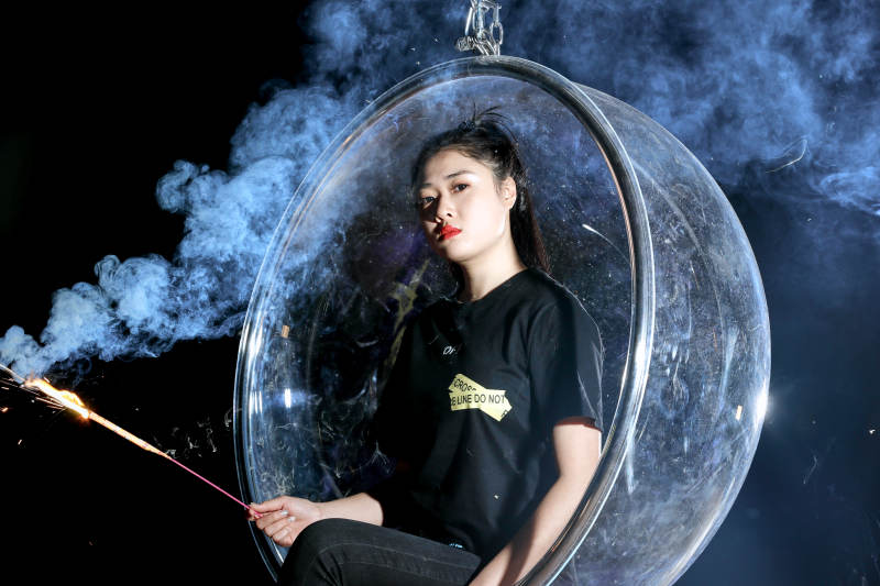 夜晚坐在透明秋千上燃放仙女棒的可爱少女图片