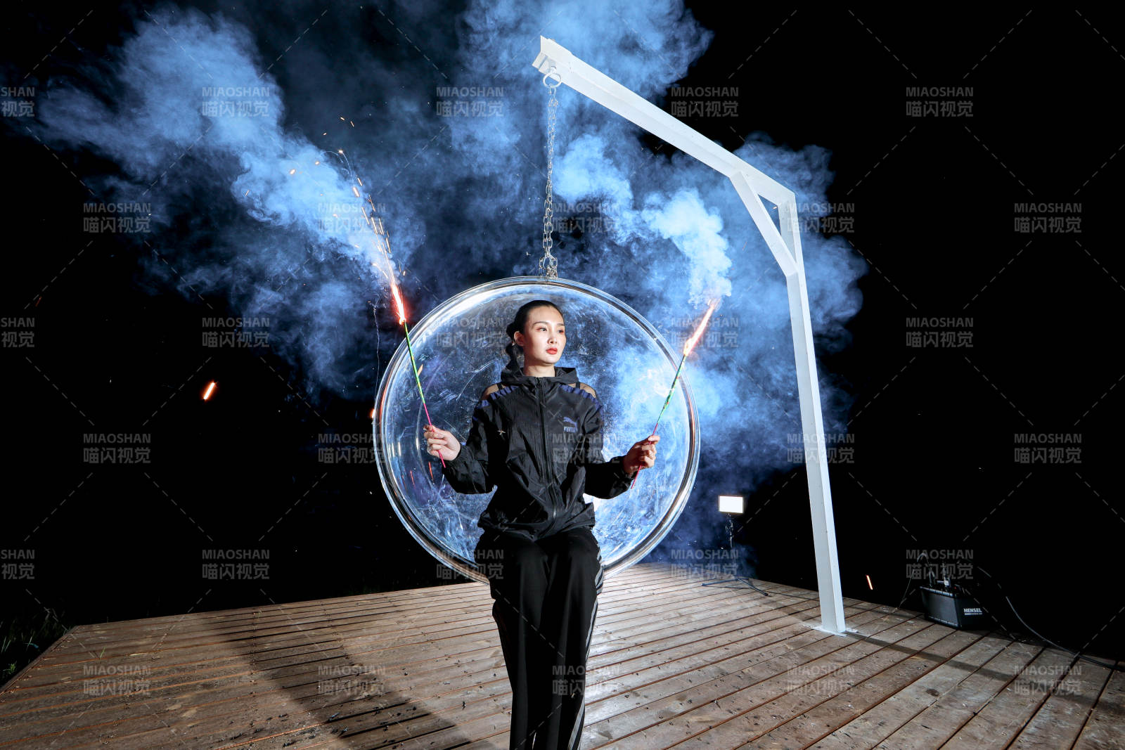 夜晚坐在透明秋千上燃放仙女棒的可爱少女图片