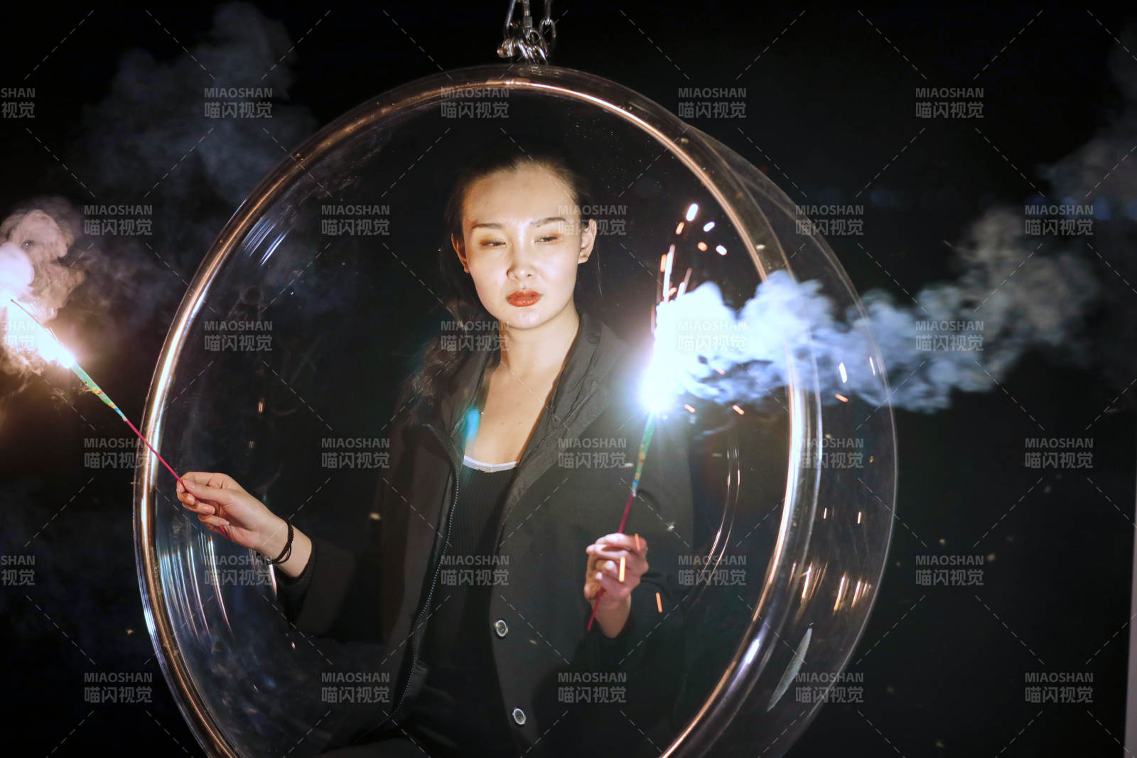 夜晚坐在透明秋千上燃放仙女棒的可爱少女图片