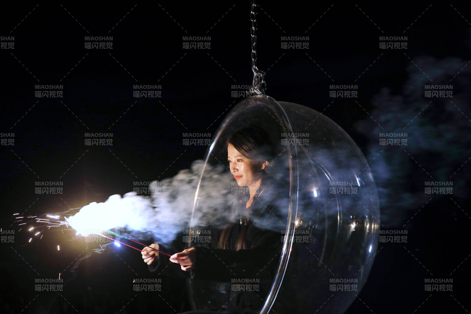 夜晚坐在透明秋千上燃放仙女棒的可爱少女图片