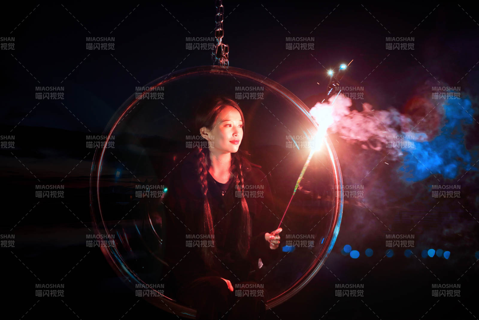 夜晚坐在透明秋千上燃放仙女棒的可爱少女图片