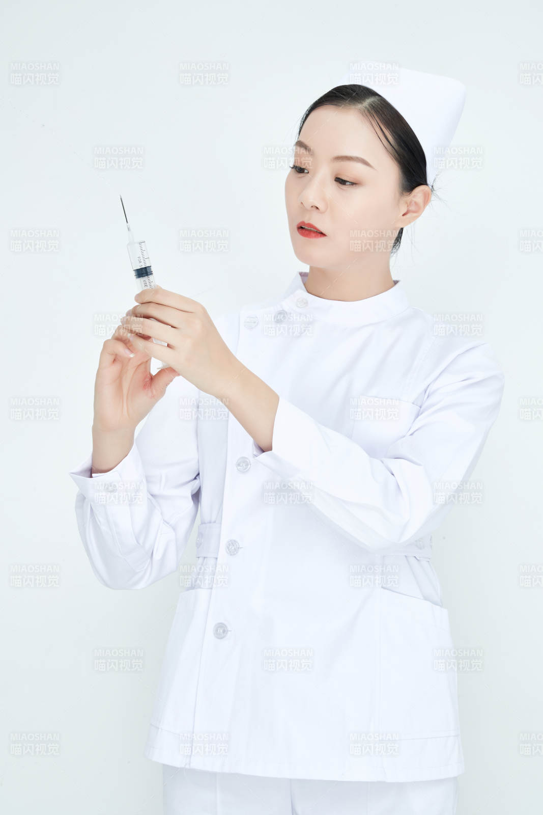 穿护士服戴口罩手执针筒的年轻女护士图片