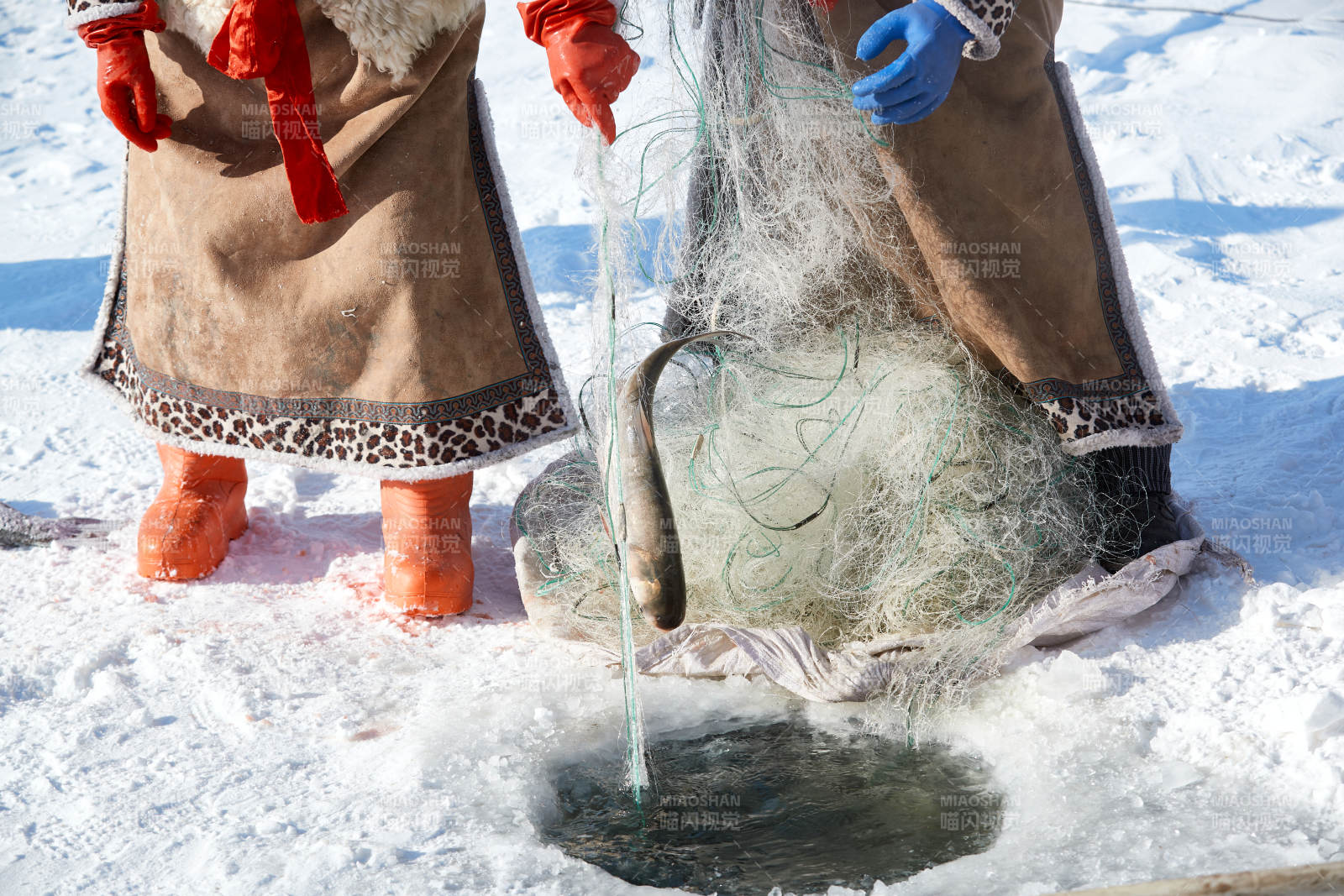 寒冷的冬季在冰冻的湖面上凿冰捕鱼图片
