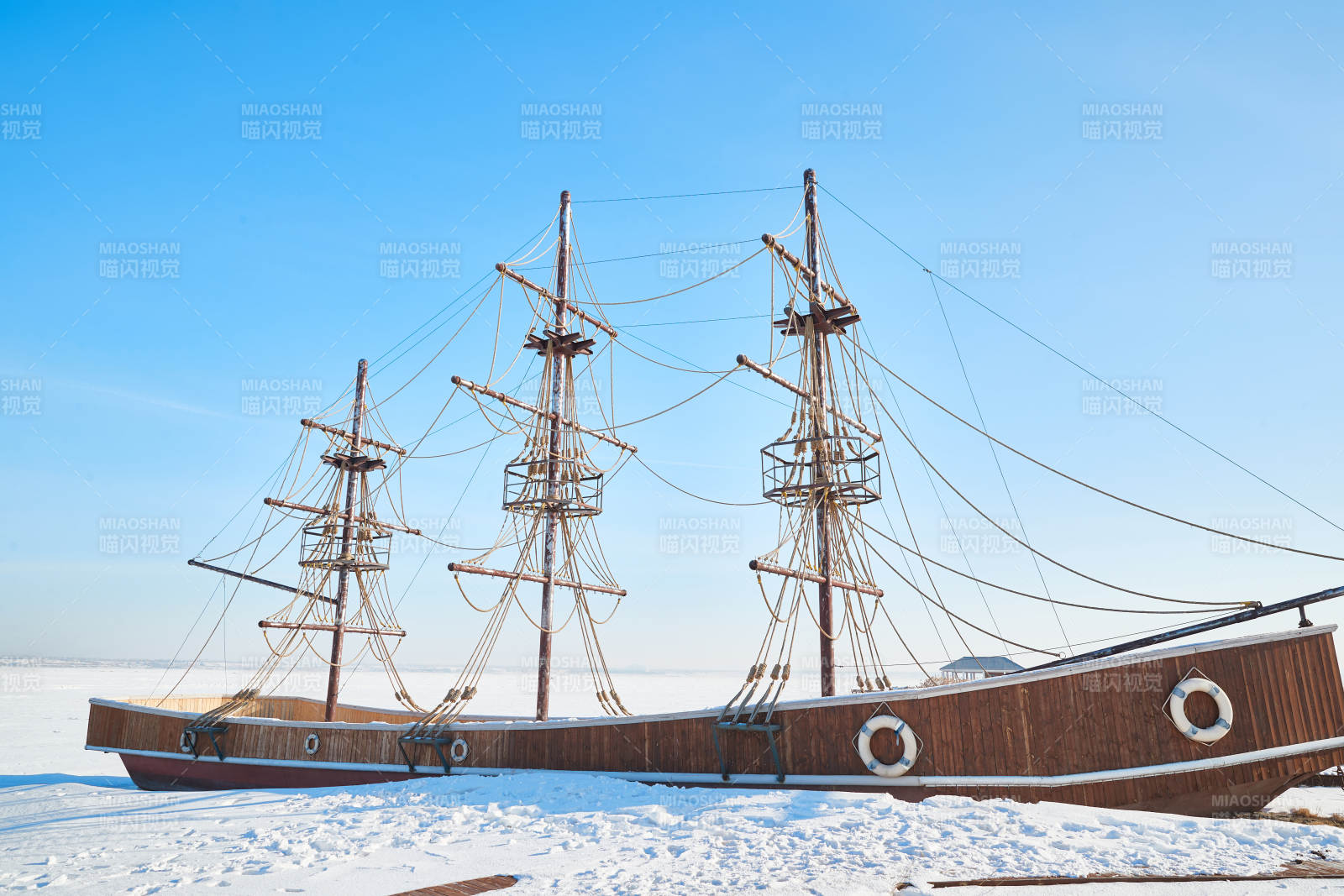 冬季停靠在冰封湖边的复古帆船图片