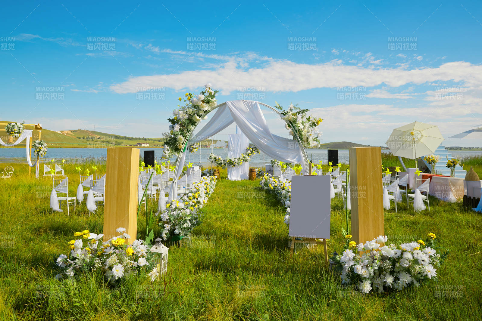 湖畔晴空下浪漫的草坪婚礼布场图片