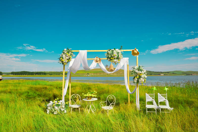 湖畔晴空下浪漫的草坪婚礼布场图片