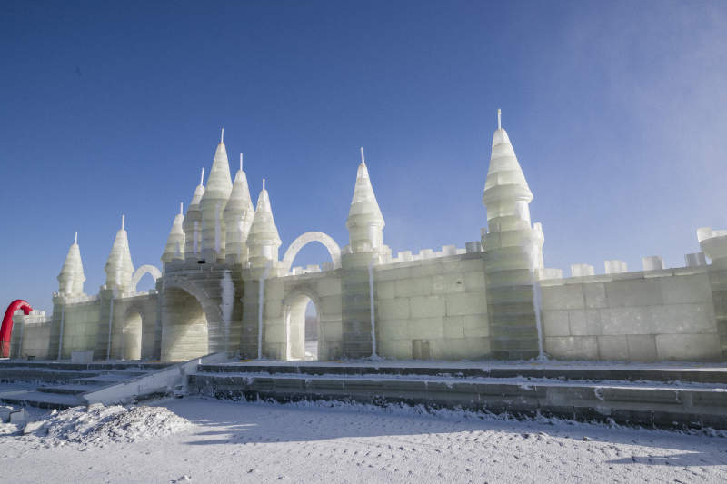 夕阳下雪原上晶莹剔透的冰雕建筑图片