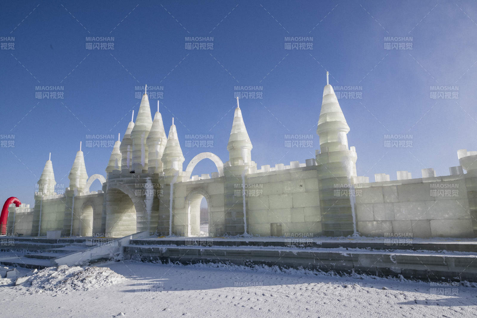 夕阳下雪原上晶莹剔透的冰雕建筑图片